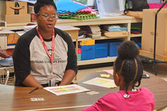 A mentor from the IU Student Success Corps tutors an elementary school student.